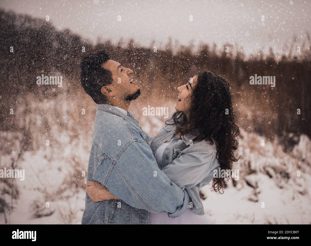 Mexican Hispanic man in denim jacket oversized and woman are kissing ...