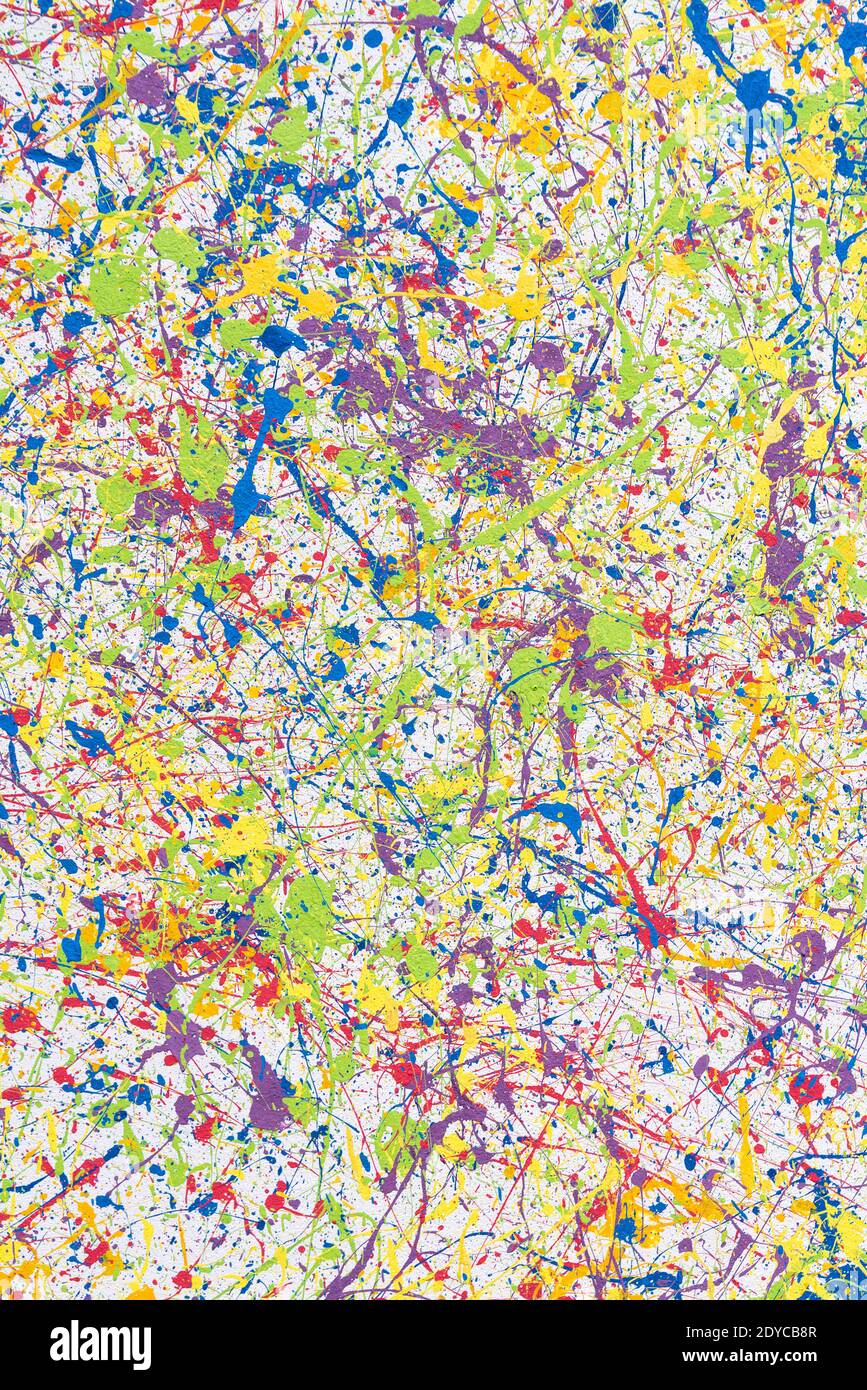 Wall with multi-colored paint splashes. Bright abstract background. Vertical frame. Stock Photo