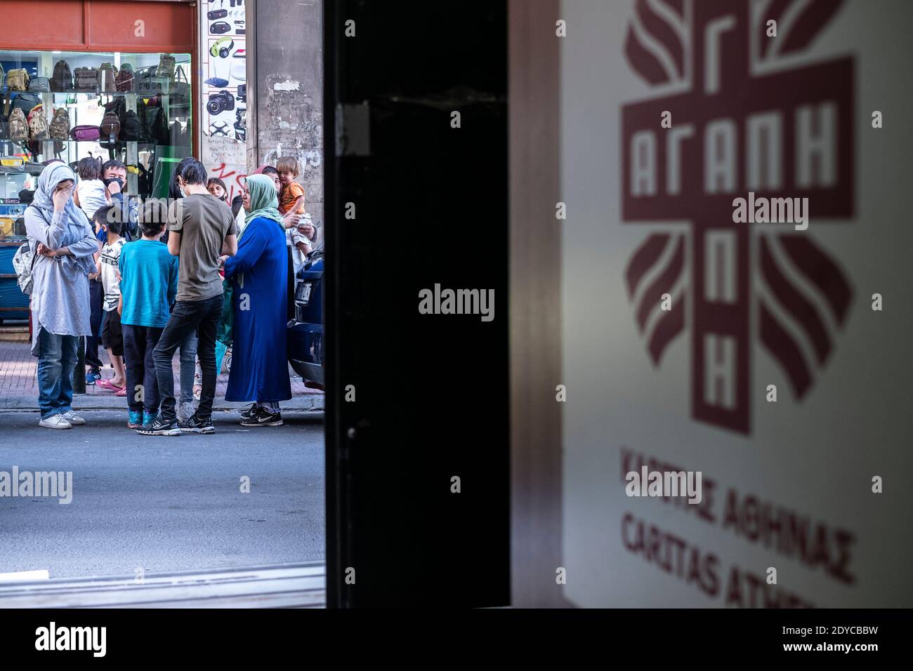 The economic crisis in Athen is mixed with the discomfort of refugees, waiting to receive basic necessities in front of the Caritas center. Stock Photo