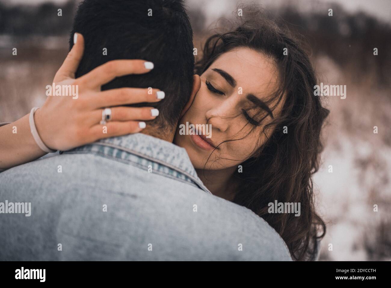 Hispanic man in denim jacket oversized and woman in love are kissing ...