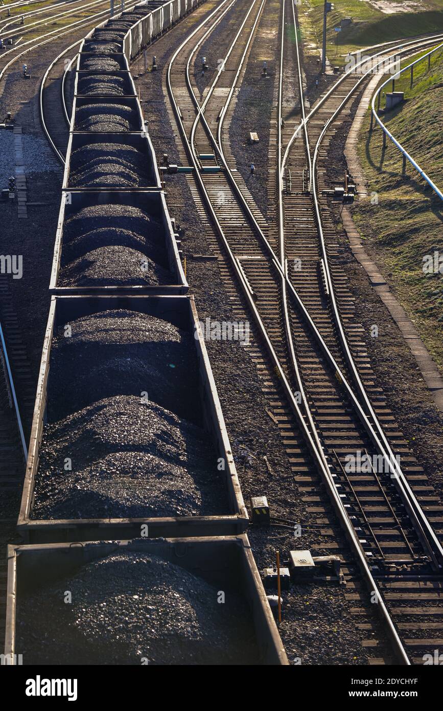 black coal in train wagons on the rails is moved to the next unloading point in logistics Stock Photo