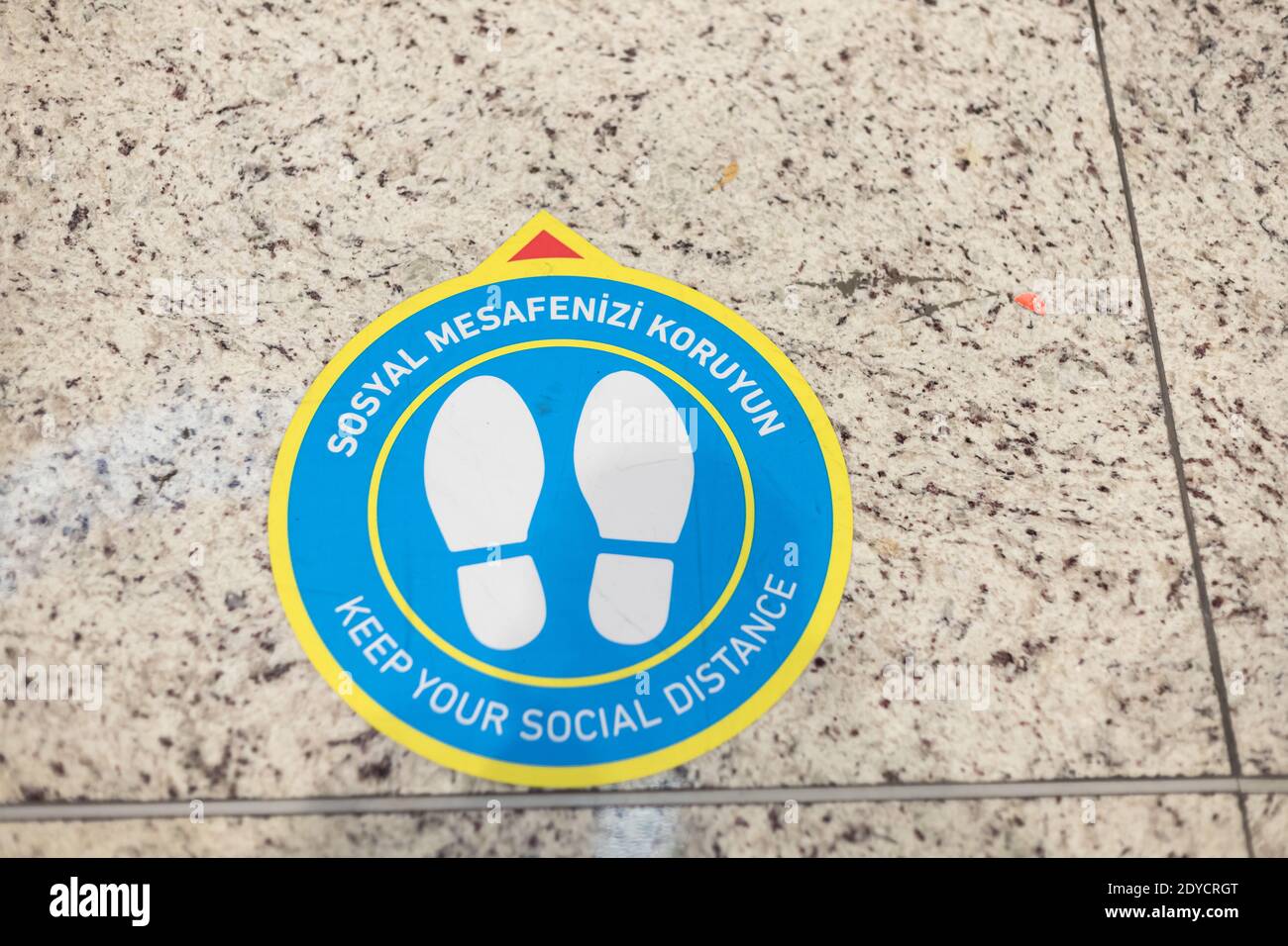 Keep Your Social Distance sign on airport floor. Coronavirus Covid-19 Stock Photo