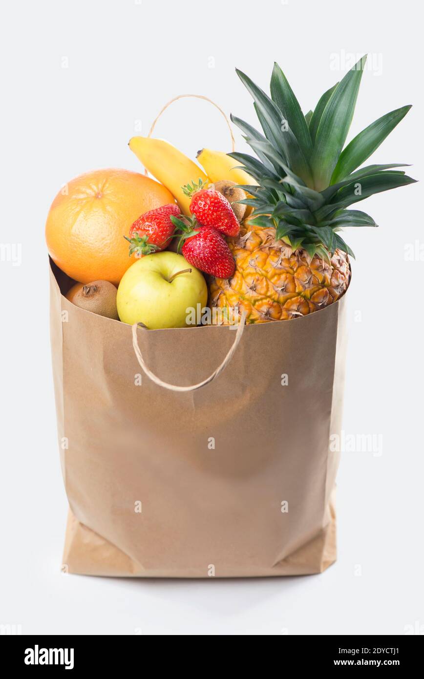 Fruits and vegetables in paper grocery bag isolated over white ...