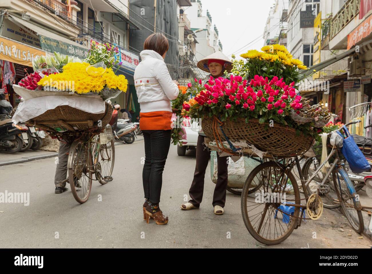 Vietnam Hanoi Flower vendor with bike filled with flowers. Stock Photo