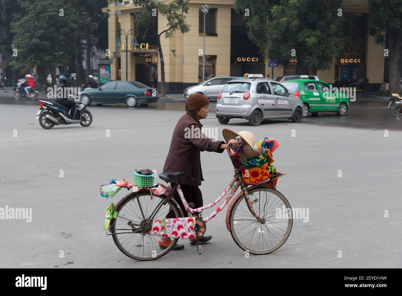 Vietnam Hanoi Old woman with decorated bike passing Gucci store Stock Photo  - Alamy