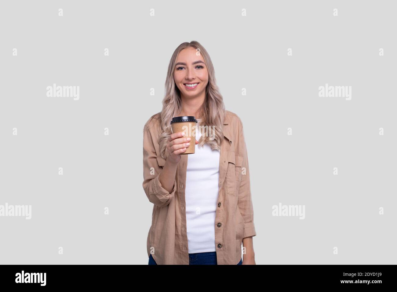 Girl Holding Take Away Coffee Cup. Girl With To Go Coffee Cup in Hands. Stock Photo