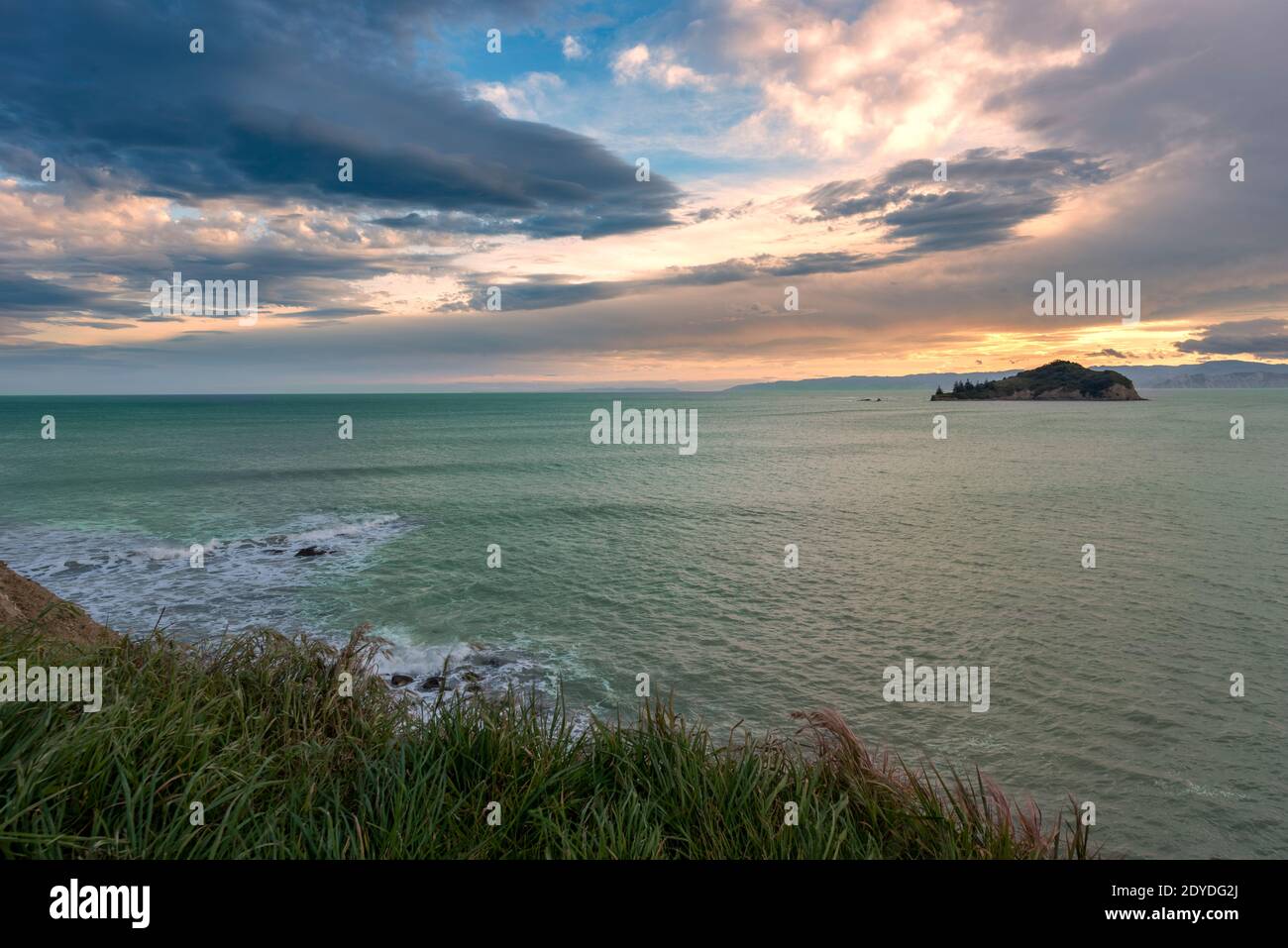 Golden sunset across an aquamarine ocean in Sponge Bay New Zealand Stock Photo