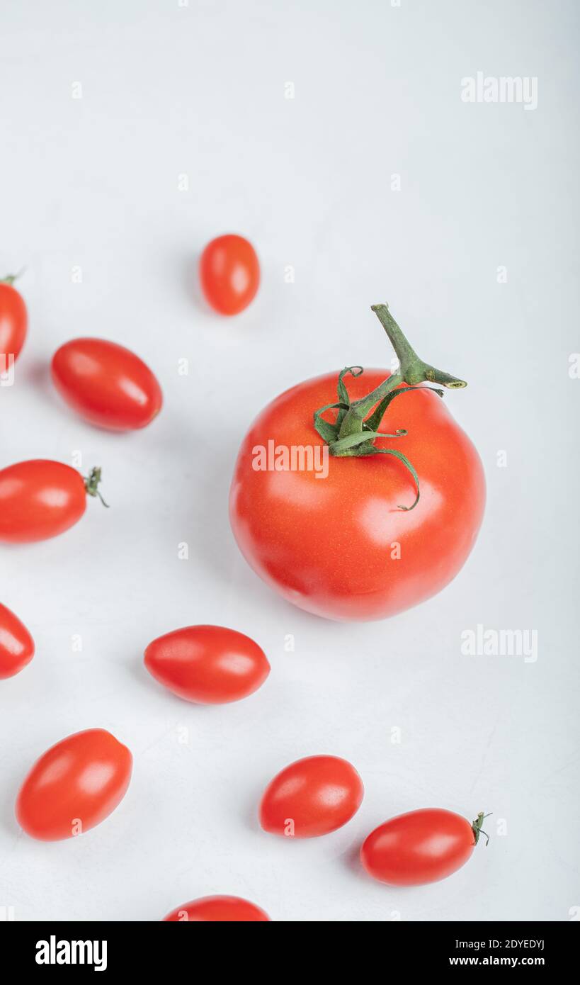 Cherry tomatoes around of normal tomato Stock Photo - Alamy