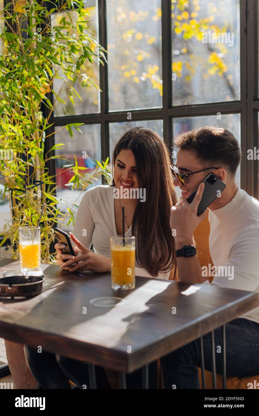 Friends socializing, having fun, and laughing drinking coffee in