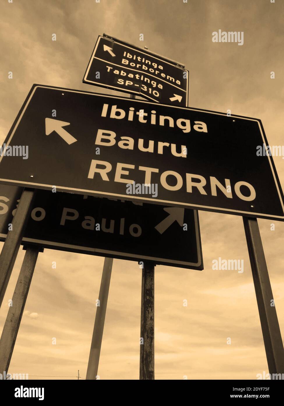 Group of metal signs indicating multiple locations in a confuse way at brazilian countryside [Sepia] Stock Photo