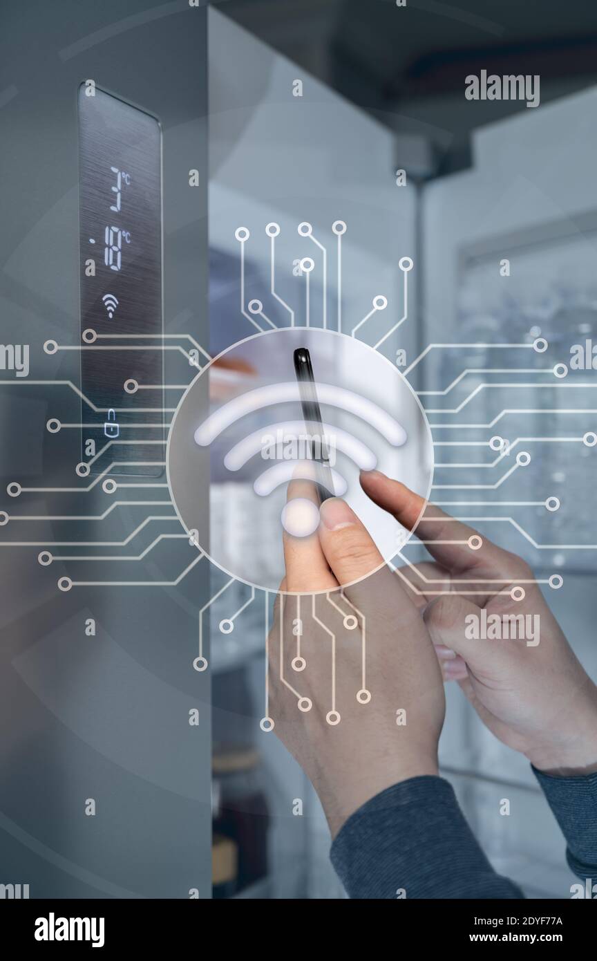 The hand of the man who controls the refrigerator with his smartphone