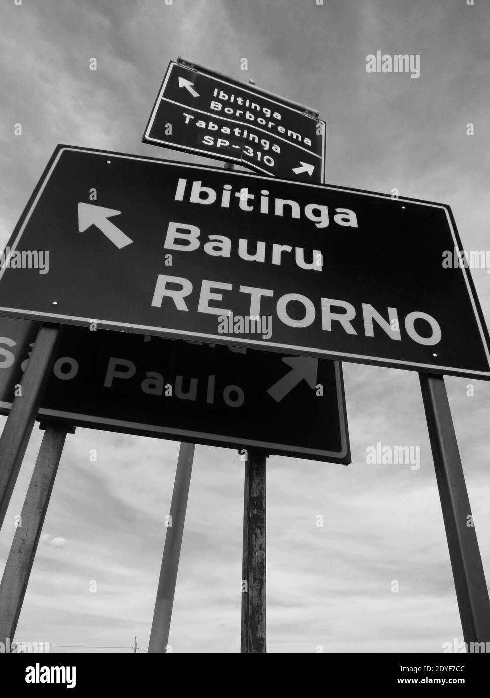 Group of metal signs indicating multiple locations in a confuse way at brazilian countryside [Black and White colors] Stock Photo