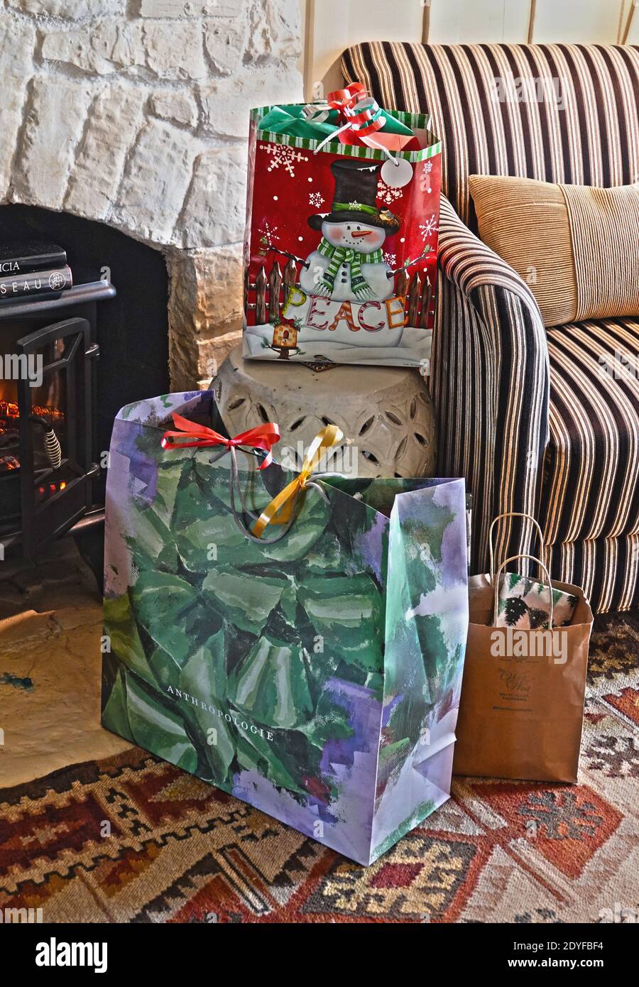 Christmas presents waiting their opening on a fireside hearth Stock Photo