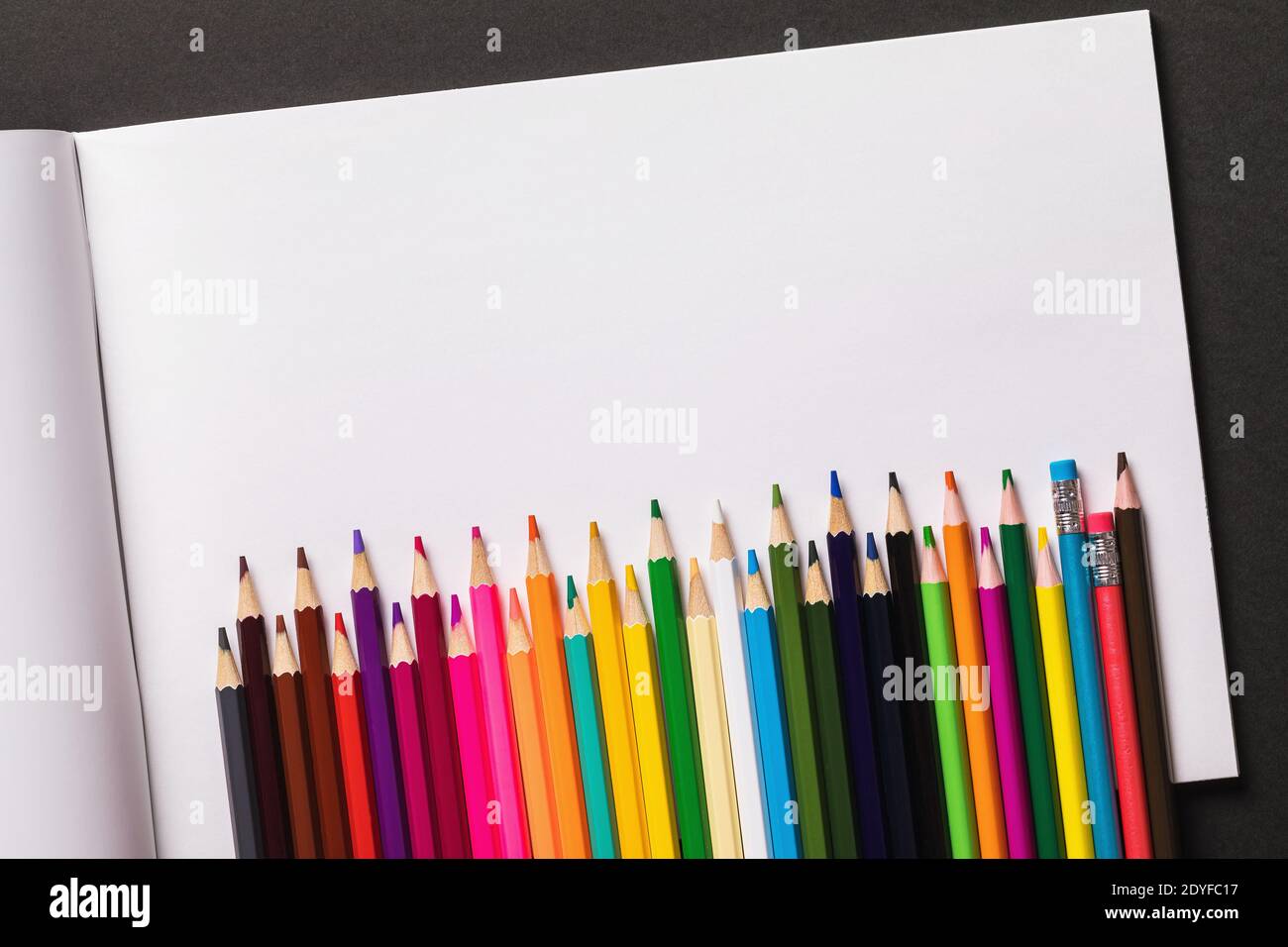 https://c8.alamy.com/comp/2DYFC17/open-sketchbook-and-colored-pencils-on-a-dark-background-with-copy-space-top-view-2DYFC17.jpg