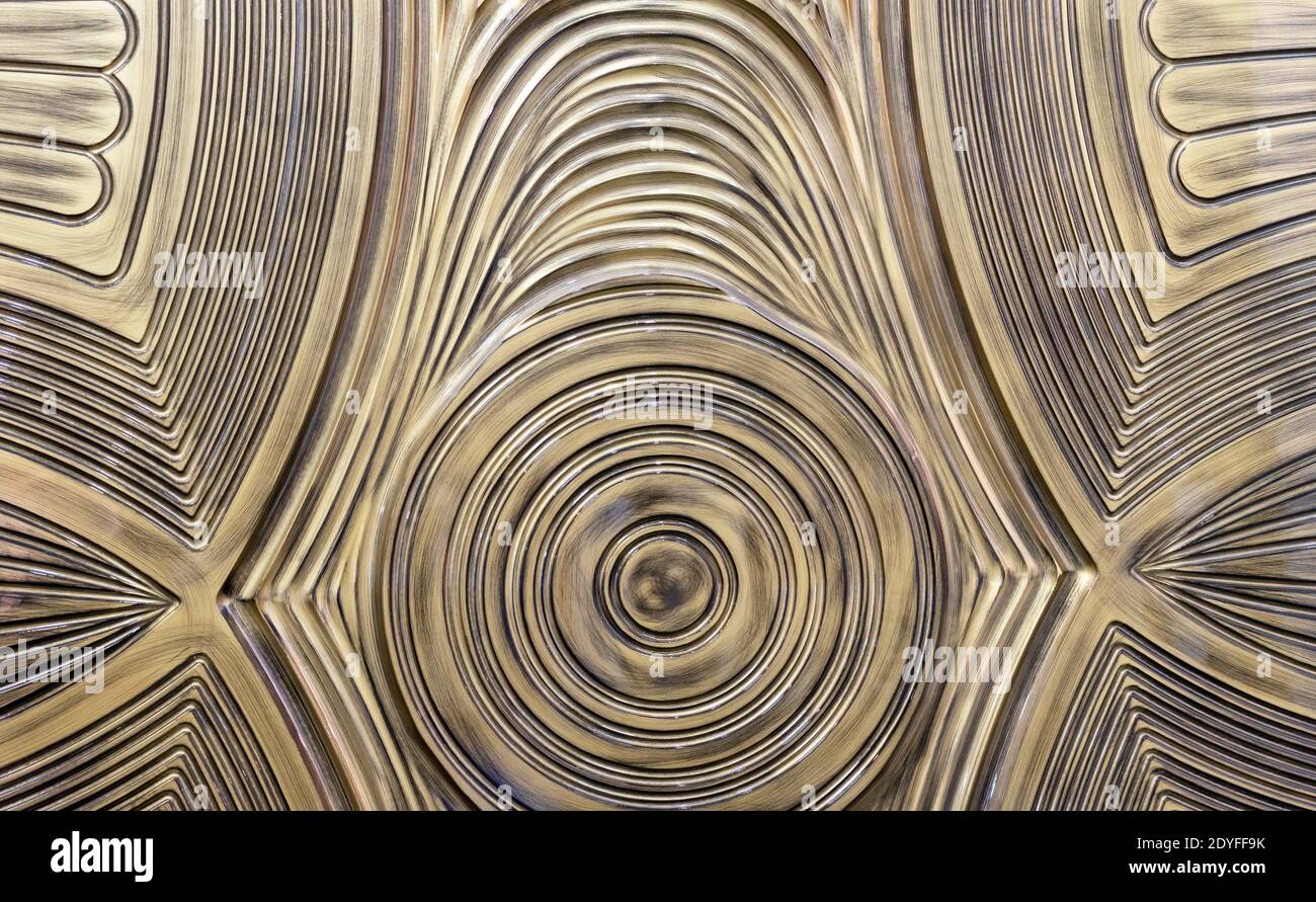 Golden with patina plastic 3D panel with wavy texture. Decorative panel with a volumetric pattern. Stock Photo