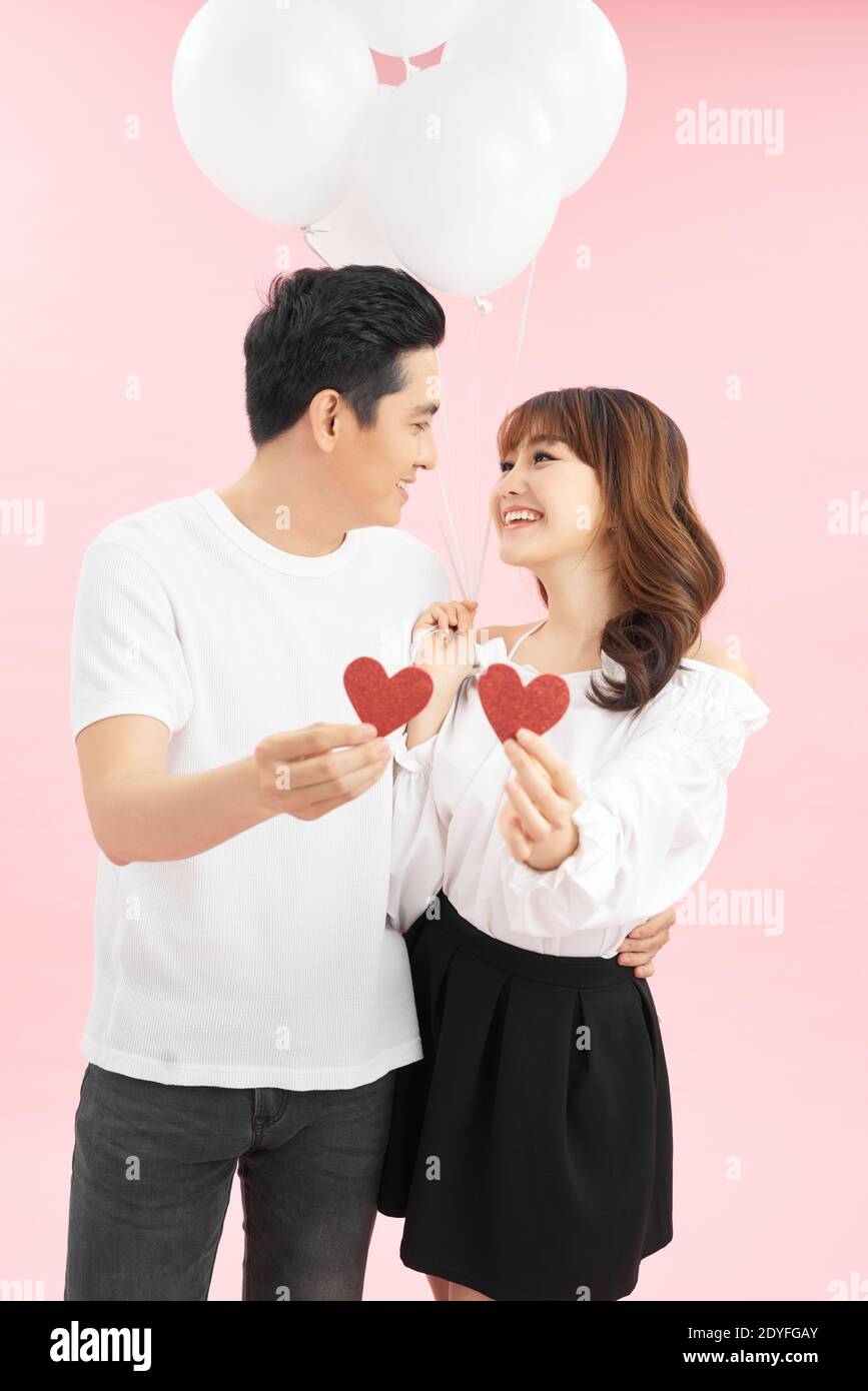 Beautiful couple in love with red balloon holding heart shape for ...
