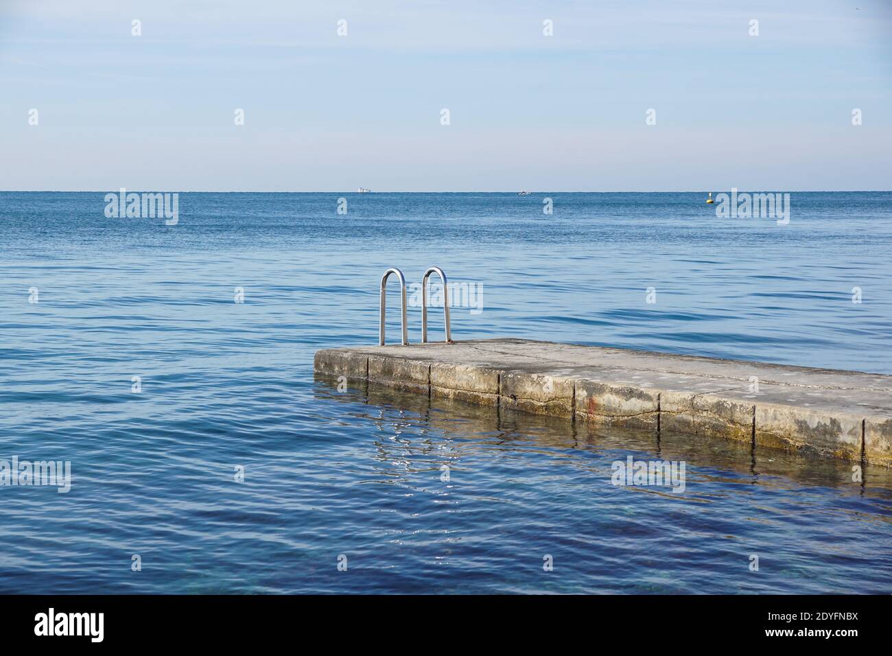 Empty pier with stairs to the sea . Stock Photo