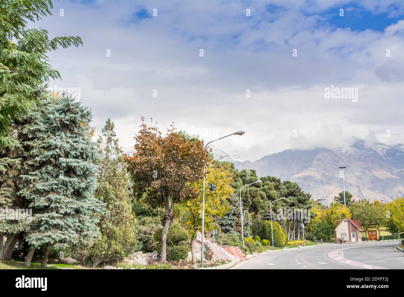 Winter Tehran street view in Tehran International Exhibition Center with snow covered Alborz Mountains against cloudy sky on background Stock Photo