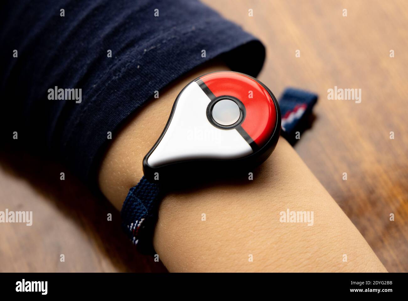 Childs hand with new Japanese game Pokemon go plus made by The Pokemon company Nintendo. Addictive popular activity among children and grownups. Stock Photo