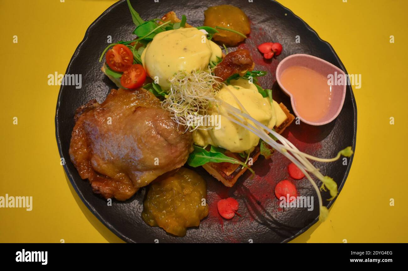 A serving of roasted chicken thighs with different sauces, cherry