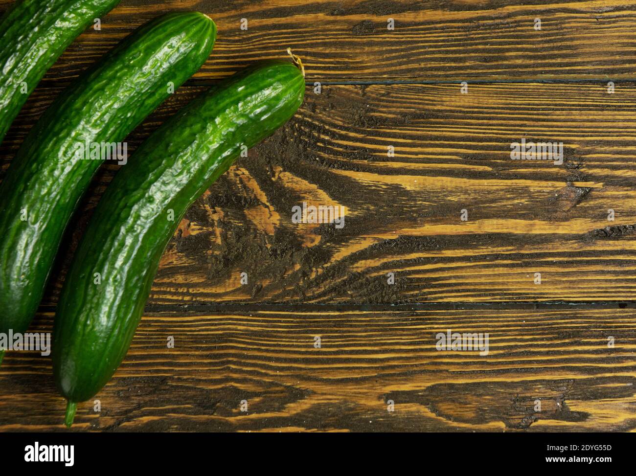 Fresh green cucumbers isolated on wooden background Stock Photo