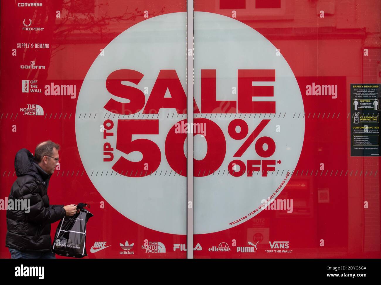 A shopper walks past a sale sign in the window of JD Sports on Commercial  road in Bournemouth during the Boxing Day sales. Boxing Day spending is  expected to fall by more