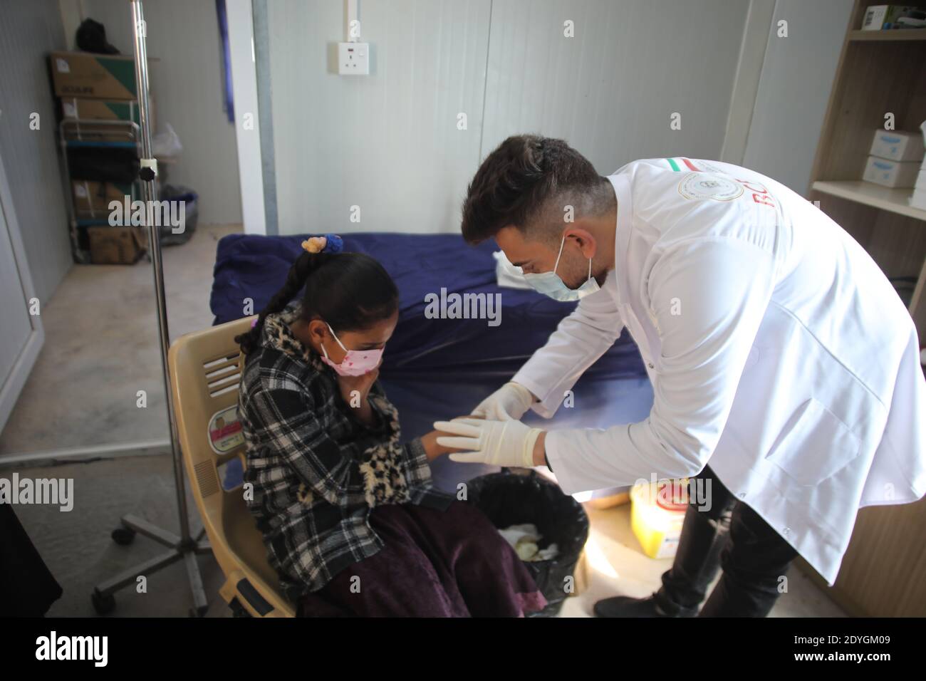 Baghdad. 26th Dec, 2020. A girl receives medical treatment at the primary health center in Hasansham U3 Camp in Nineveh province, Iraq, Dec. 8, 2020. The ongoing COVID-19 pandemic has raised vulnerability levels of Internal Displaced People (IDP) in Iraq. Aid agencies can't do as much to help, and containing the contagious virus in camps is becoming more difficult. Credit: Xinhua/Alamy Live News Stock Photo