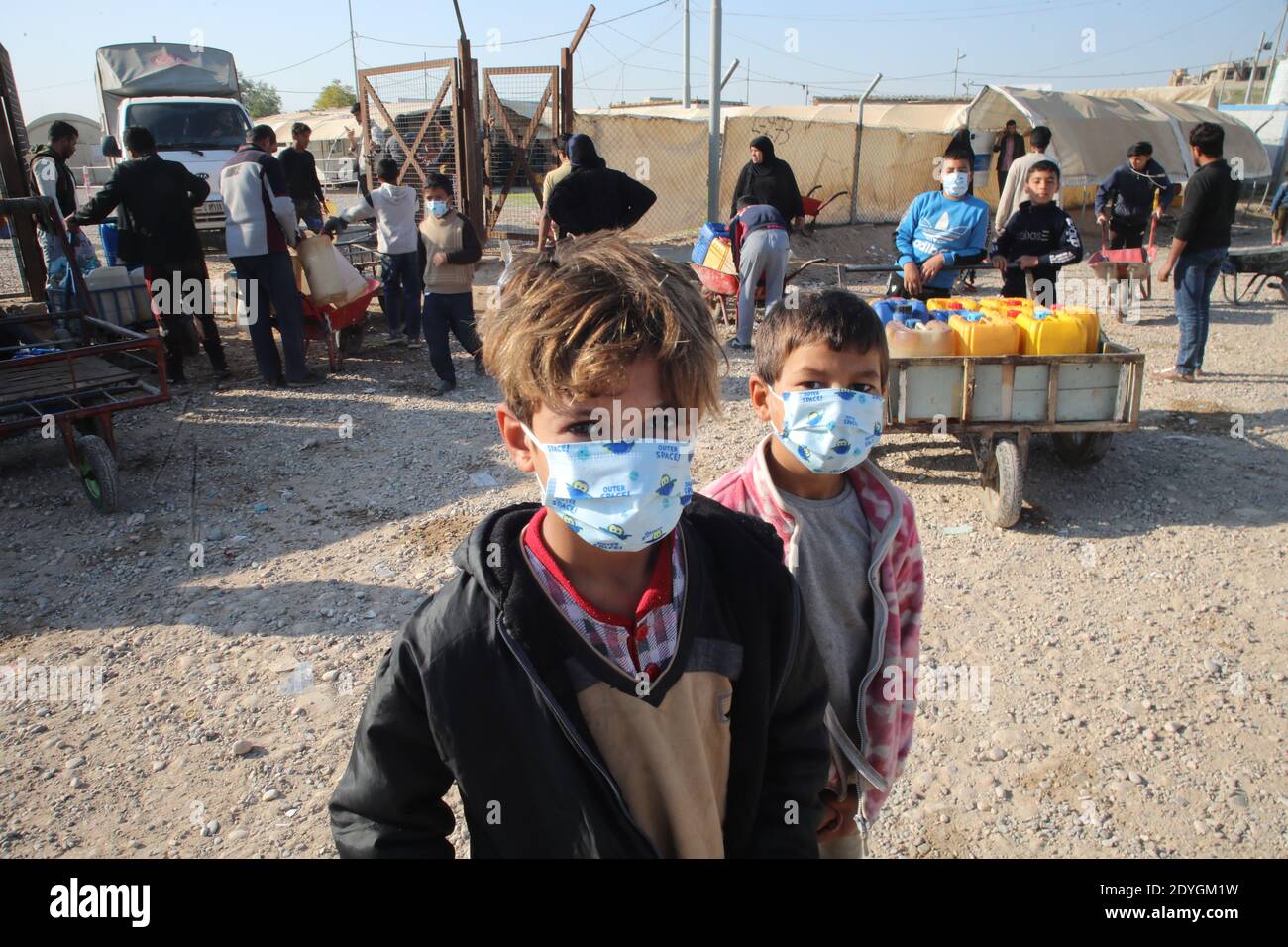 Baghdad. 26th Dec, 2020. Children wearing masks are seen outside fuel distribution site in Hasansham U3 Camp in Nineveh province, Iraq, Dec. 8, 2020. The ongoing COVID-19 pandemic has raised vulnerability levels of Internal Displaced People (IDP) in Iraq. Aid agencies can't do as much to help, and containing the contagious virus in camps is becoming more difficult. Credit: Xinhua/Alamy Live News Stock Photo