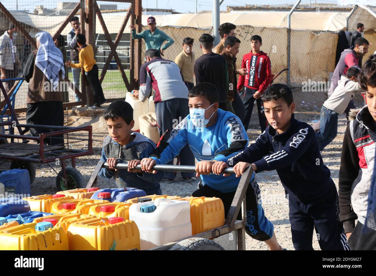 Baghdad. 26th Dec, 2020. Children receive fuel distribution in Hasansham U3 Camp in Nineveh province, Iraq, Dec. 8, 2020. The ongoing COVID-19 pandemic has raised vulnerability levels of Internal Displaced People (IDP) in Iraq. Aid agencies can't do as much to help, and containing the contagious virus in camps is becoming more difficult. Credit: Xinhua/Alamy Live News Stock Photo