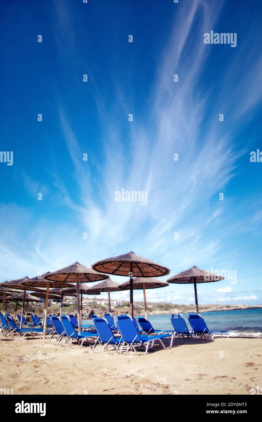 Umbrellas and chairs at the ready on Kalathas beach near Chania, Crete. Stock Photo