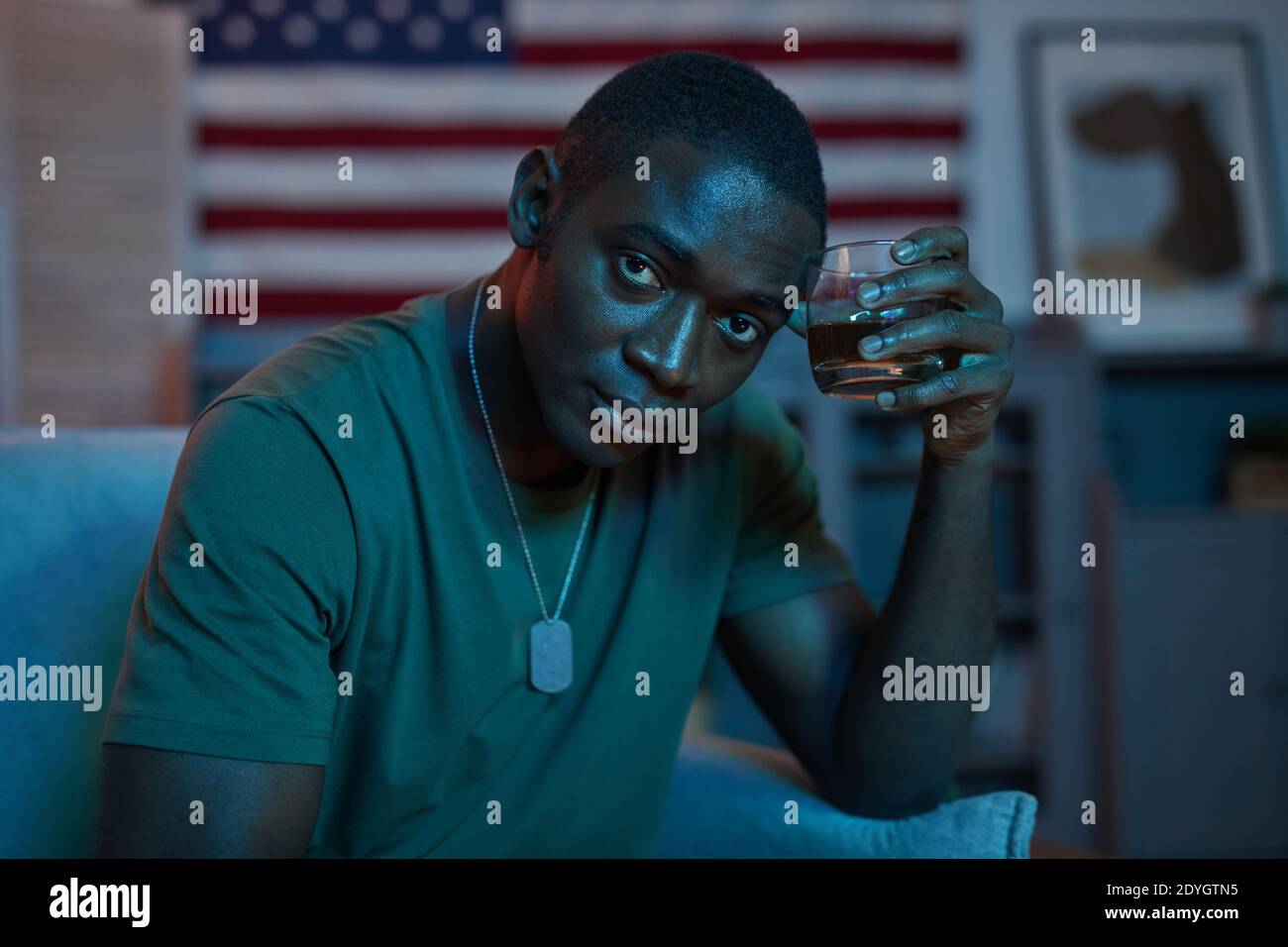 Portrait of African young soldier looking at camera while drinking alcohol Stock Photo