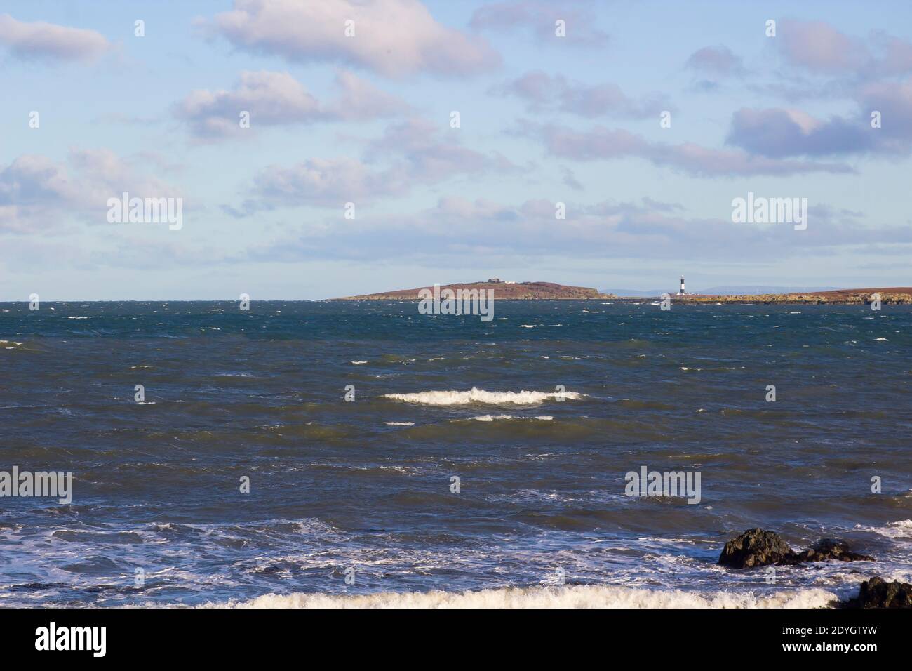24 December 2020 A view of the rough seas across the Copeland Sound towards the Copeland Islands and Mew lighthouse on a bright winter afternoon. Stock Photo