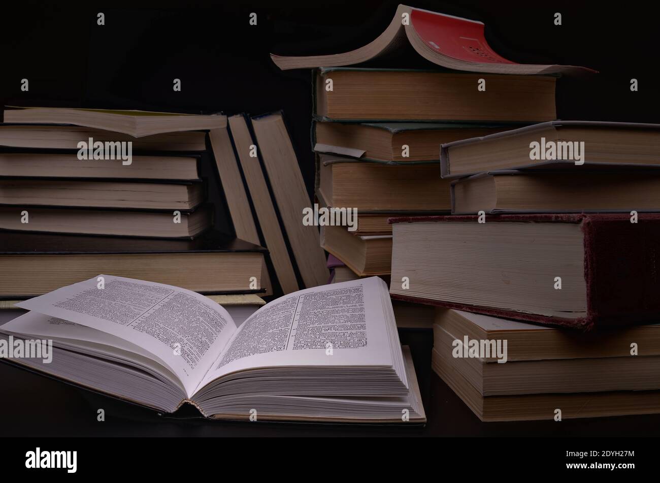 open book and pile of books against a dark background Stock Photo