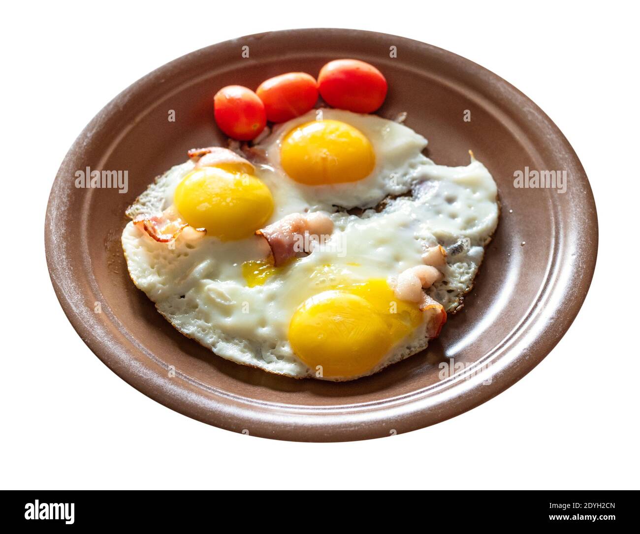 three fried eggs with bacon on brown ceramic plate cut out on white background Stock Photo