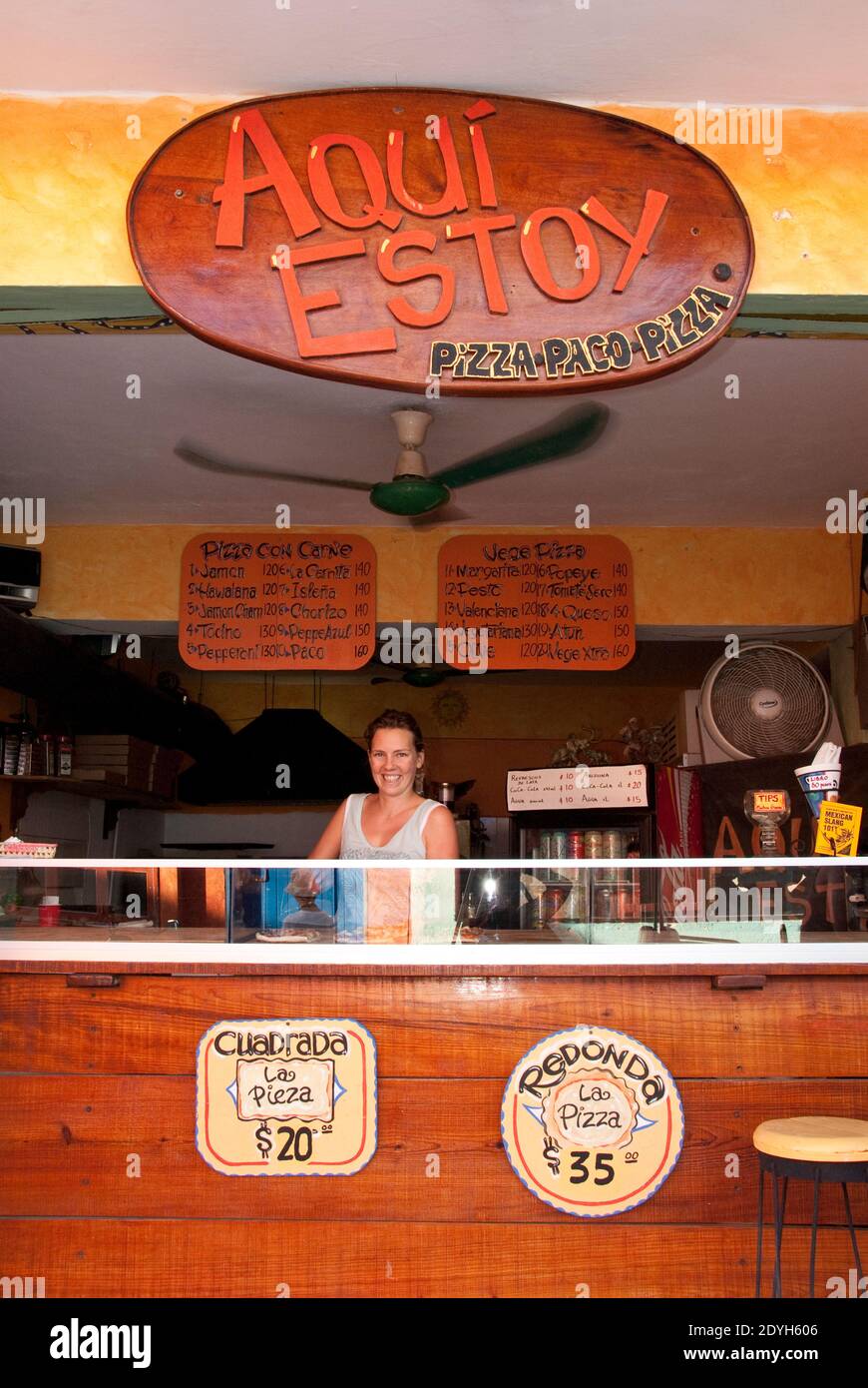 A woman makes pizza at Aqui Estoy pizza shop, Isla Mujeres, Mexico