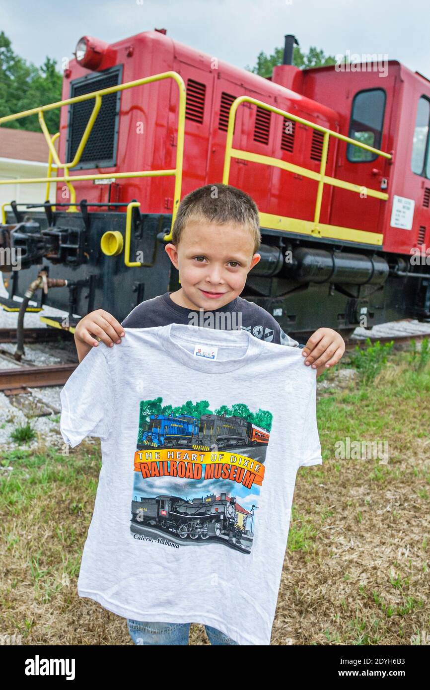 Alabama Calera Heart of Dixie Railroad Museum,boy kid child visitor caboose train holding souvenir tee shirt, Stock Photo