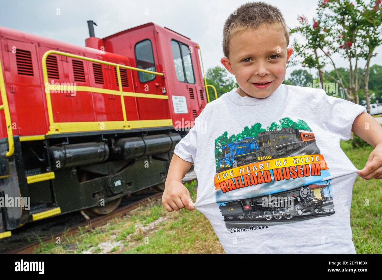 Alabama Calera Heart of Dixie Railroad Museum,boy kid child visitor caboose train holding souvenir tee shirt, Stock Photo