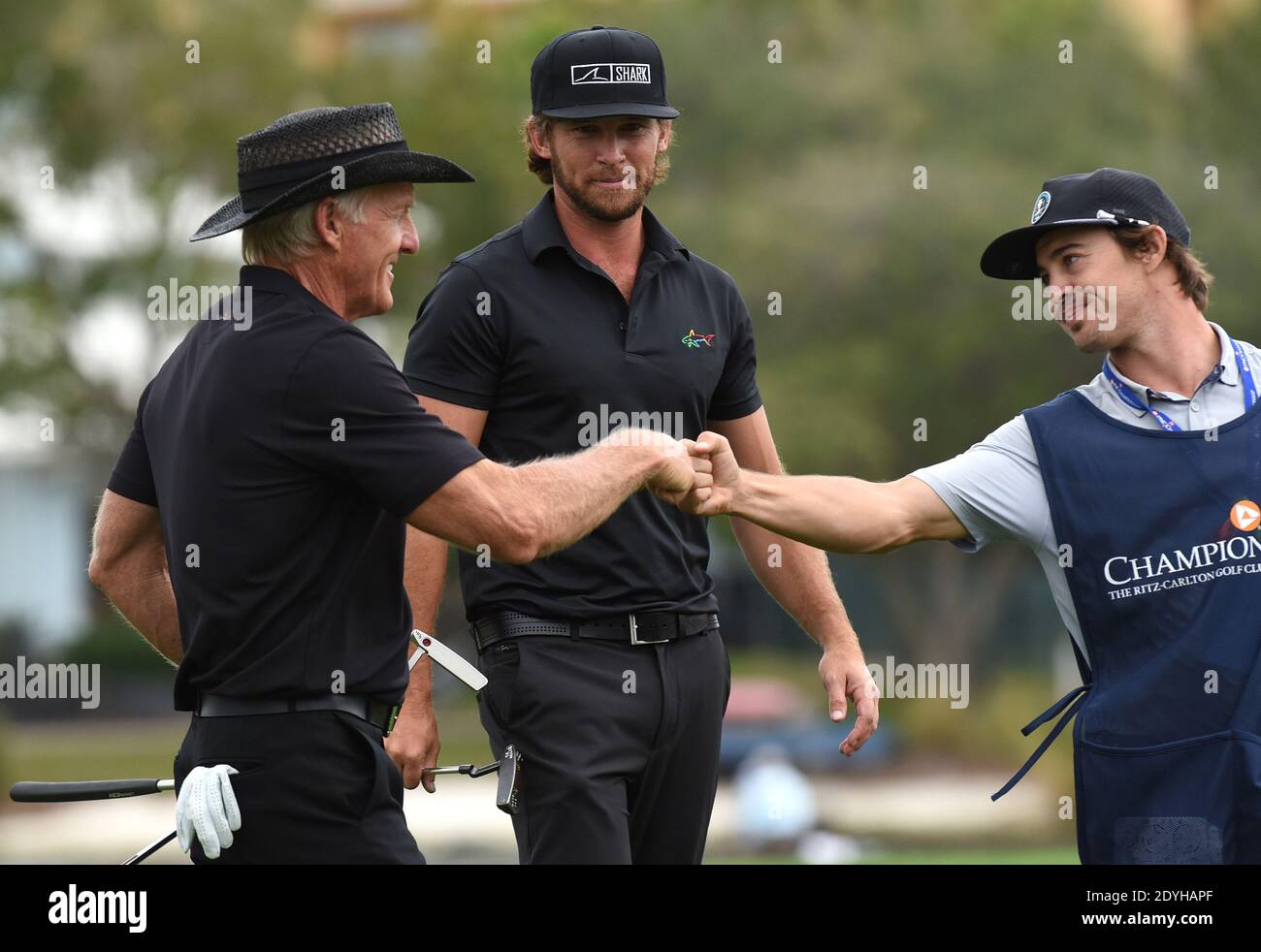 December 20, 2020 - Orlando, Florida, United States - Australian Greg Norman (left) and his son, Greg Norman Jr. fist bump with a caddie after completing the final round at the PNC Championship golf tournament at the Ritz-Carlton Golf Club on December 20, 2020 in Orlando, Florida. On Christmas Day, Norman posted a photo to Instagram from a hospital bed where he was being treated for COVID-19 symptoms. NormanÕs son also posted a photo to Instagram, stating that he and his fiancee have tested positive for the COVID-19 virus. (Paul Hennessy/Alamy) Stock Photo