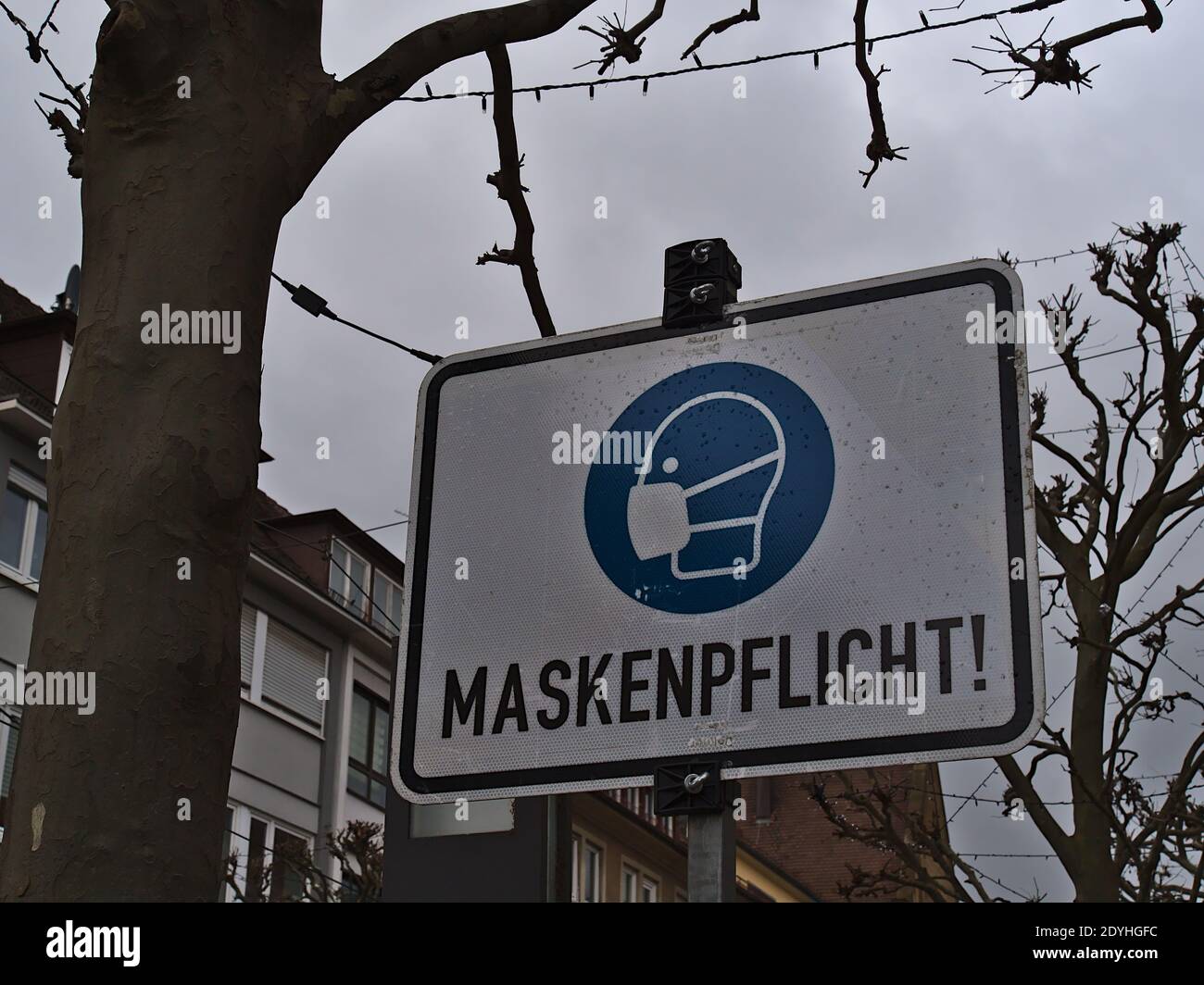 Sign informing about the obligation to wear a protective face mask ('Maskenpflicht') in pedestrian zone and shopping street Kaiserstraße in center. Stock Photo