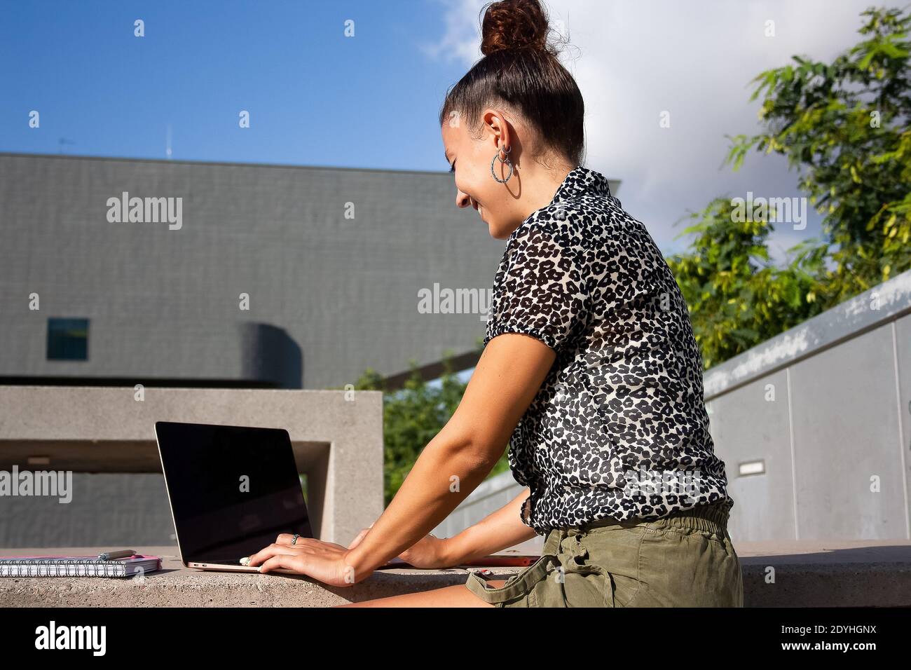 Young woman remote working with her laptop on a outside location Stock Photo