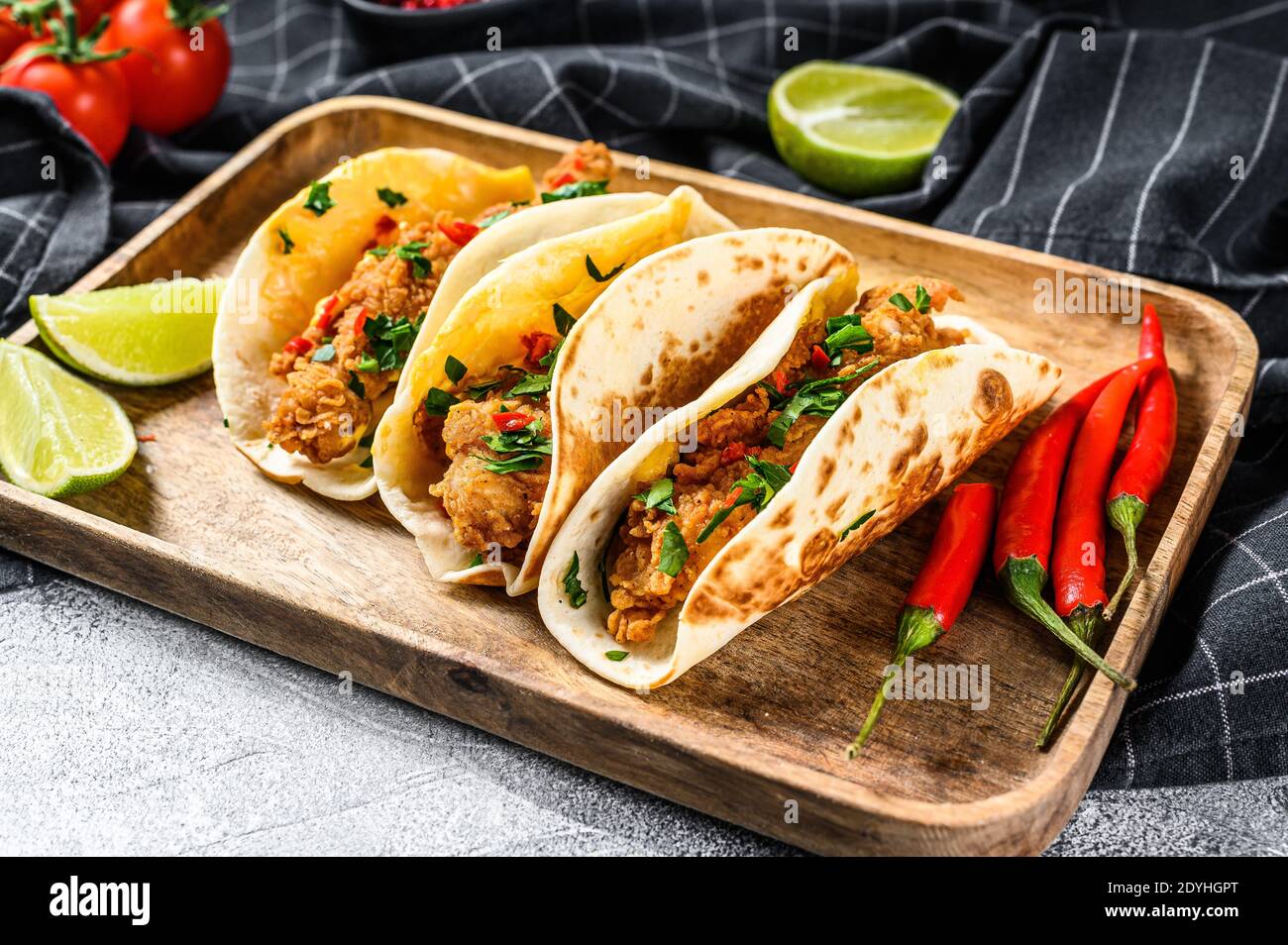 Tacos with crispy chicken, parsley, cheese and chili peppers. White