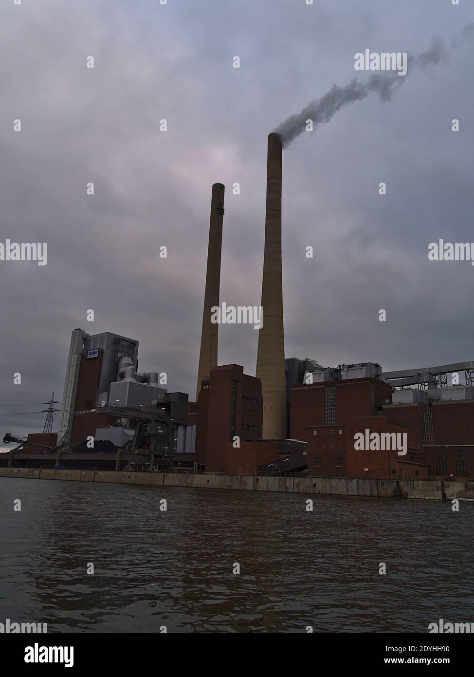 Big chimney stacks of coal-fired Heilbronn Power Station operated by Energie Baden-Württemberg (ENBW) on the shore of Neckar river on winter day. Stock Photo