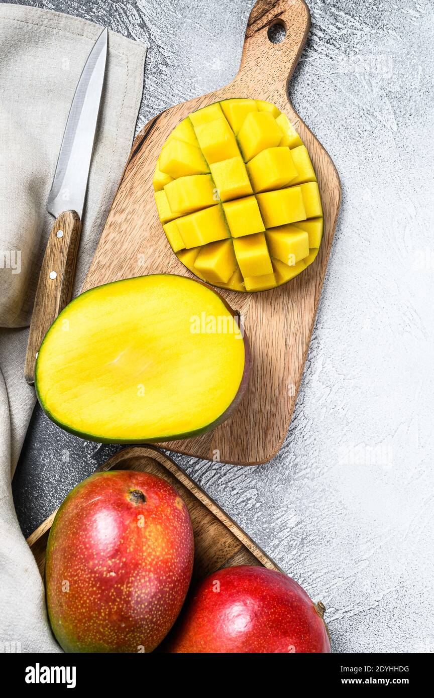 Mango fruit cut into cubes on a cutting Board. Gray background. Top view Stock Photo