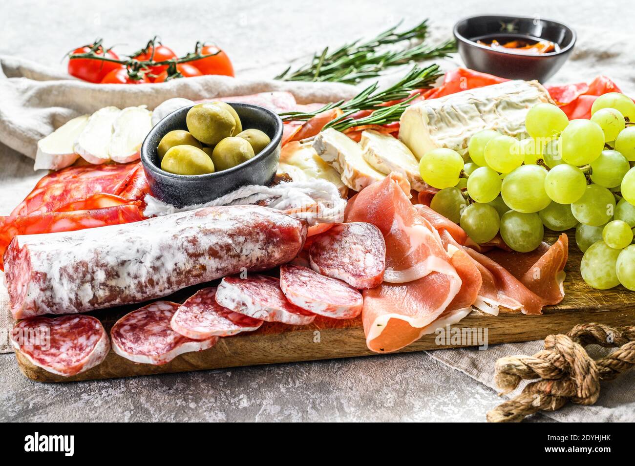 Italian antipasto, wooden cutting board with prosciutto, ham, parma