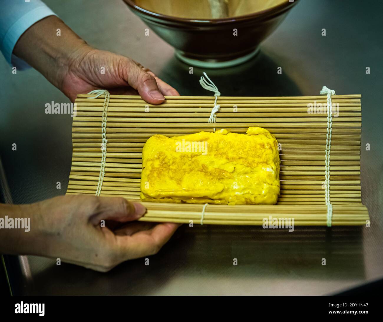 Workshop: Preparing a Bento Box in Izunokuni, Japan. The fried omelet is shaped in a bamboo mat. This makes it easier to cut the loaf into portions Stock Photo