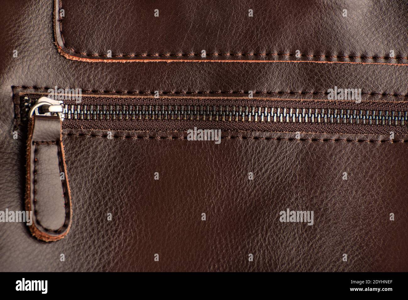 Zipper on brown leather product. Keychain puller. Close up. Stock Photo