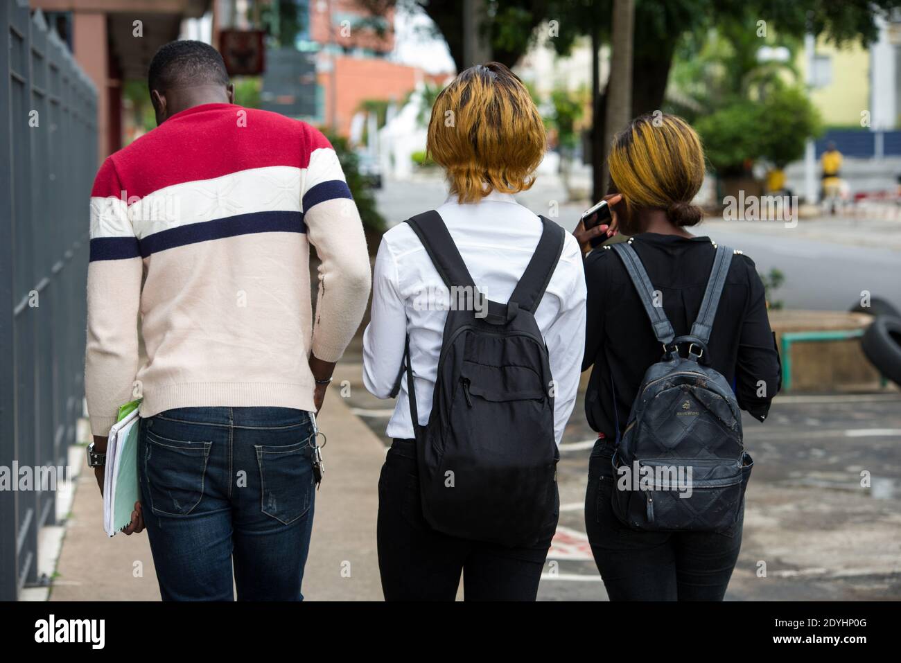 Group of young people with backpacks walking in the city. Conviviality, travel, vacation, sightseeing, city tour, exchange program between students. Stock Photo