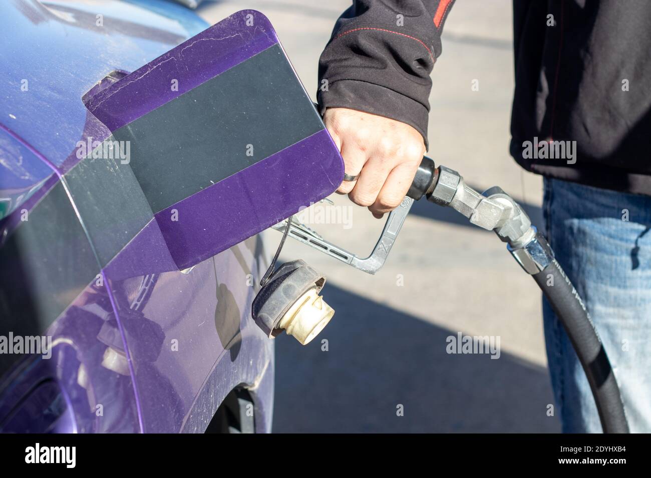 Man holding gas pump filling up car with gas close up . High quality