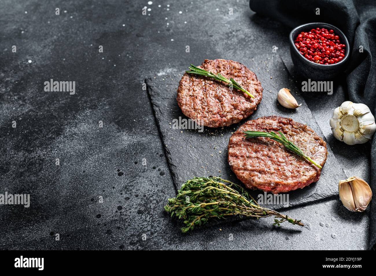 Grilled ground beef patties. BBQ meat. Black background. Top view. Copy
