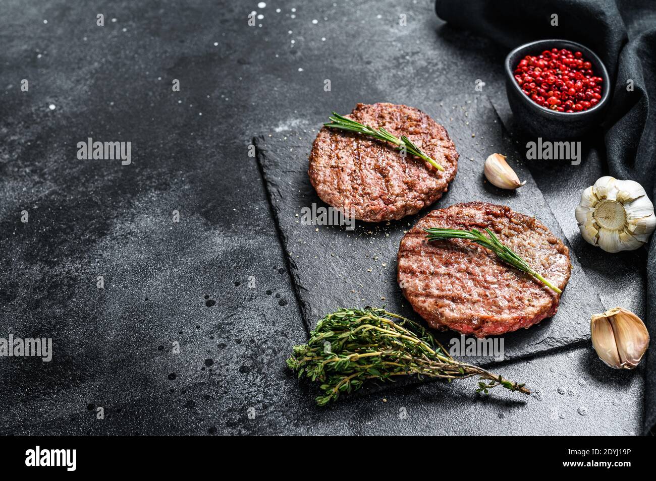 Grilled ground beef patties. BBQ meat. Black background. Top view. Copy space Stock Photo